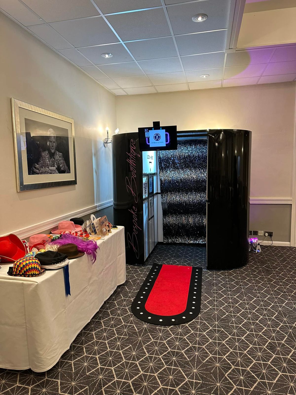 Black magic mirror booth with red carpet and a props table
