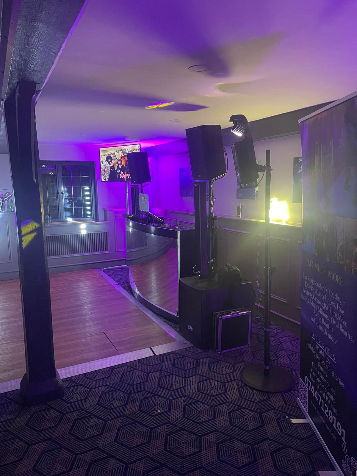 Event room lit with purple lighting and DJ speakers